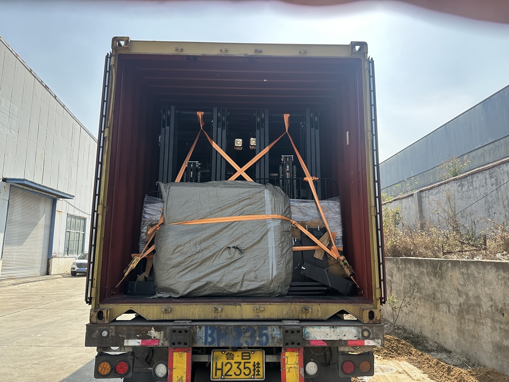Electric forklifts secured inside a shipping container for export.
